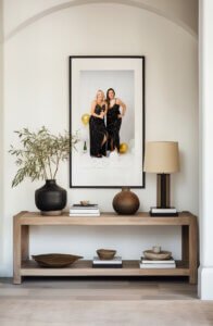 Framed portrait of two women celebrating a 40th birthday photoshoot with confetti and gold balloons, displayed in a stylish living room.
