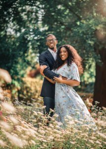 Couple standing in a field of flowers during their outdoor couple photography session in Nottingham.