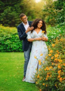 Couple posing in a garden surrounded by yellow flowers during their couple photoshoot in Nottingham.