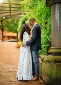 Couple kissing under a pergola during their outdoor couple photography session in Nottingham.