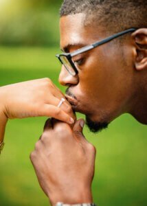 Man kissing woman's hand with engagement ring during a romantic couple photoshoot in Nottingham.
