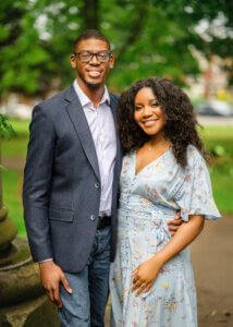 Engaged couple smiling at the camera during an outdoor couple photography session in Nottingham.