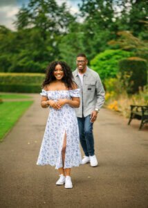 Engaged couple having fun during their Nottingham engagement photography session, with the woman walking ahead and the man playfully following.