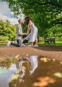 Man proposing to his fiancée with their reflection in a puddle during a Nottingham engagement photoshoot.