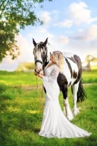 Woman in a white dress bonding with her horse during an equestrian photoshoot