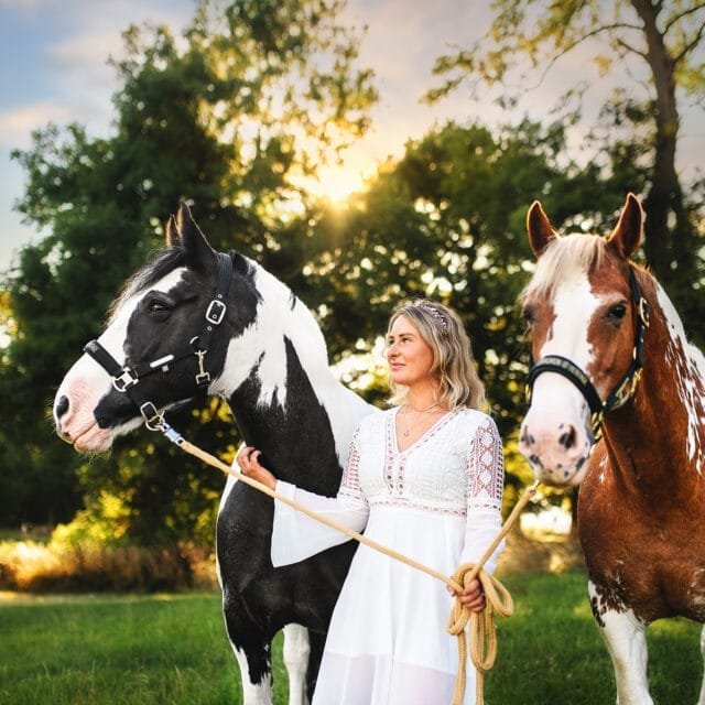 Woman with two horses at sunset during a horse photoshoot