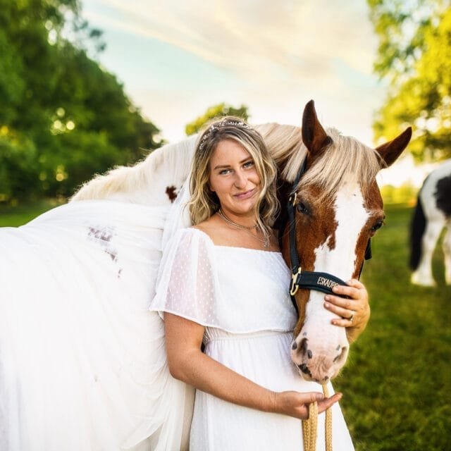 Woman in a white dress hugging her horse during a horse photoshoot