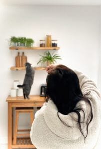 Photographer capturing wooden shelf decor with cat, in Nottingham product photography studio.