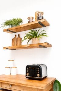 Rustic wooden shelves styled with kitchen decor, including a vintage toaster and potted plants, for product photography in Nottingham.