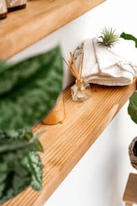 Decorative wooden shelf with blanket, diffuser, and plant, styled for Nottingham product photography studio.