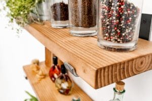 Close-up view of rustic wooden shelf with pepper jars, highlighting textures in Nottingham product photography.