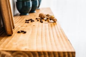 Rustic wooden shelf with scattered coffee beans, highlighting Nottingham product photography studio's attention to detail.