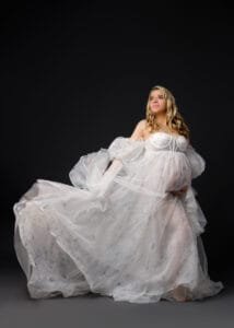 Elegant solo maternity portrait with a flowing white gown, perfect for a studio baby bump photoshoot in Nottingham.