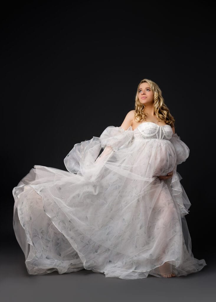 Elegant solo maternity portrait with a flowing white gown, perfect for a studio baby bump photoshoot in Nottingham.