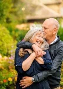 Romantic couple photoshoot in Nottingham with affectionate embrace in natural garden setting during golden hour