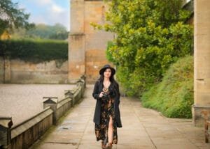 Nottingham Family Photographer Marta Szulc walking outdoors with camera at historic location in Nottinghamshire during personal branding portrait session