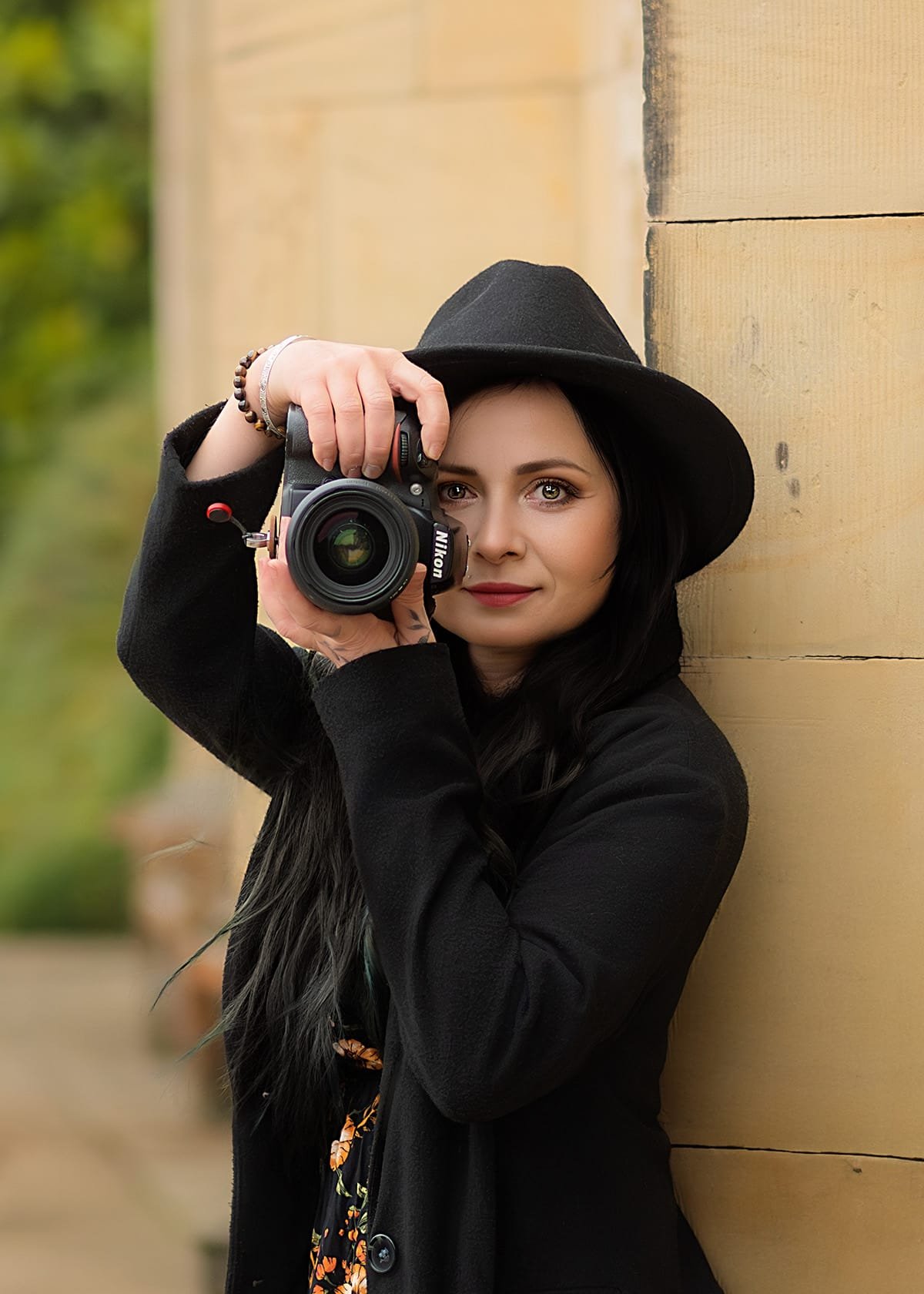 Nottingham family photographer Marta Szulc holding a Nikon camera during an outdoor portrait session in Nottinghamshire